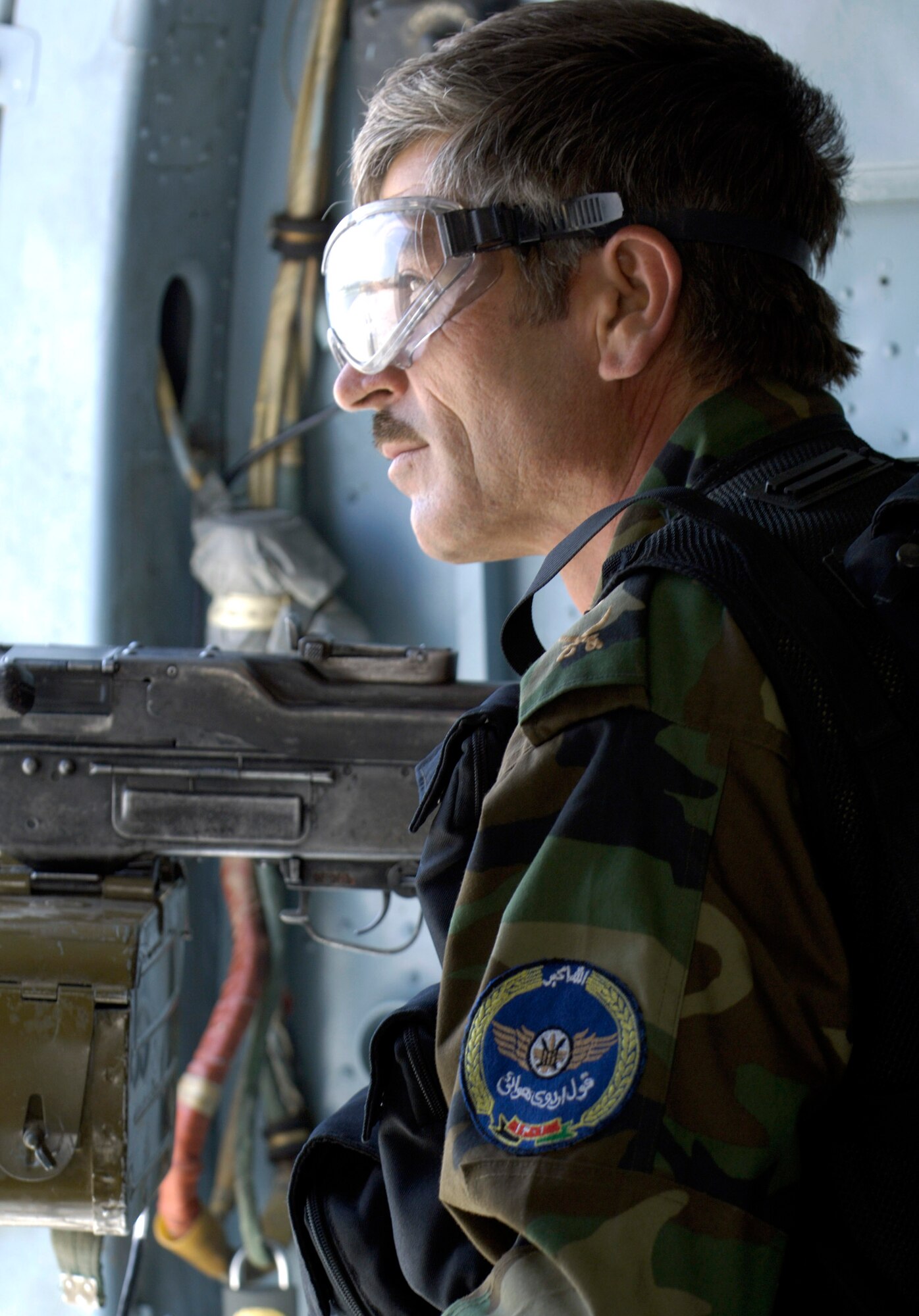 An MI-17 helicopter door gunner from the Afghan National Army air corps keeps a watchful eye during a mission July 25 flown from Kabul International Airport in Afghanistan. U.S. Airmen mentor the ANA soldiers and are assigned to the Combined Security Transition Command-Afghanistan with headquarters on Camp Eggers in Kabul. (U.S. Air Force photo/Master Sgt. Jim Varhegyi)