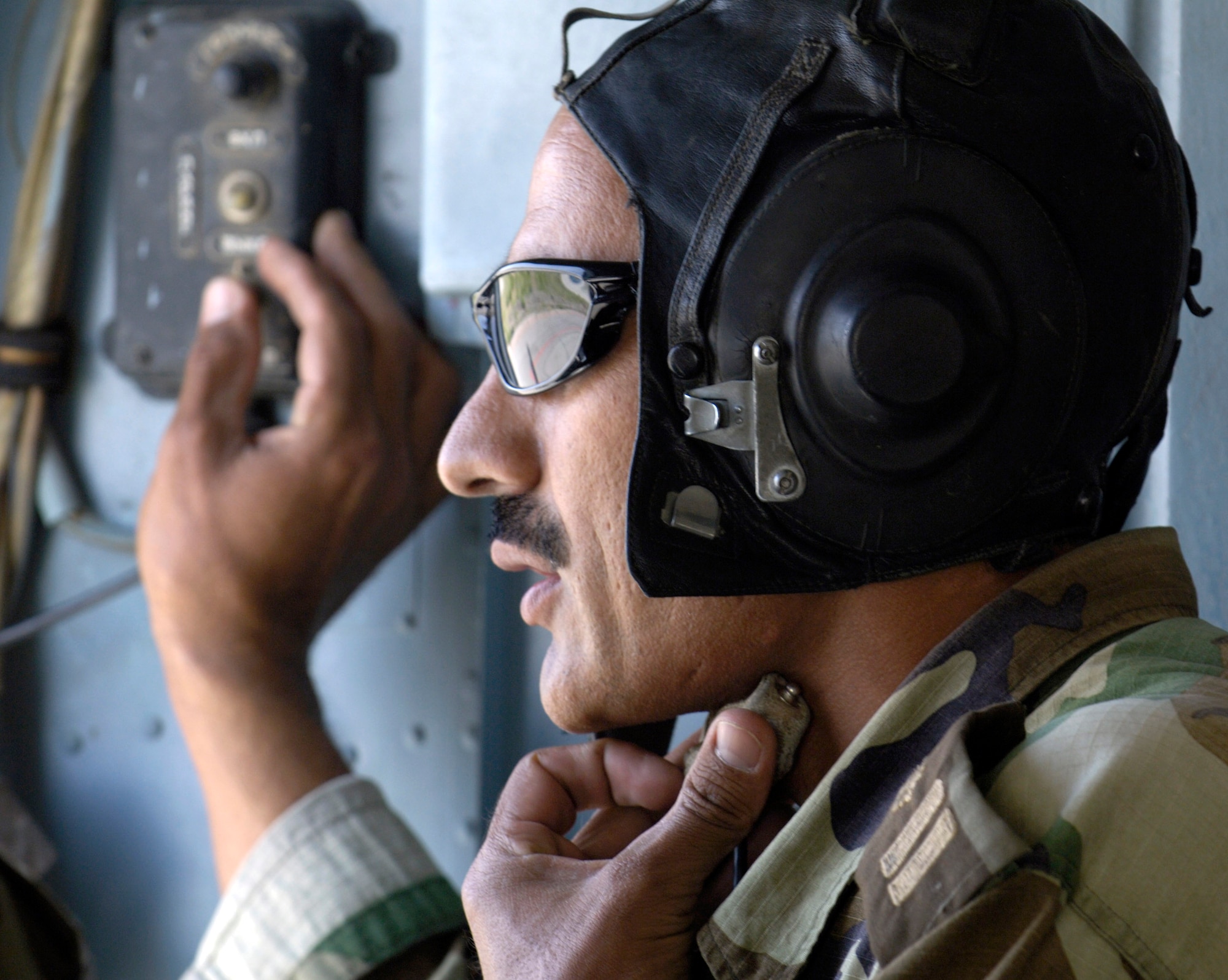 An MI-17 helicopter flight engineer from the Afghan National Army air corps gives a status report to his commanding pilot during a mission July 25 flown from Kabul International Airport in Afghanistan.  U.S. Airmen mentor the ANA soldiers and are assigned to the Combined Security Transition Command-Afghanistan with headquarters on Camp Eggers in Kabul. (U.S. Air Force photo/Master Sgt. Jim Varhegyi)
