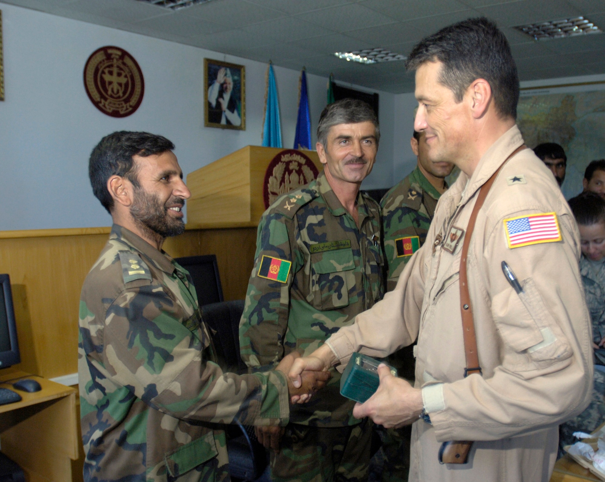 Brig. Gen. Frank Padilla congratulates members of an MI-17 helicopter flight crew from the Afghan National Army air corps July 25 at Kabul International Airport in Afghanistan. The flight crew successfully completed a mission during Operation Shukran where, for the first time, an ANA-only flight crew successfully inserted and extracted ANA commandos during the joint ANA and International Security Assistance Force operation. General Padilla is the Combined Air Power Transition Force commanding general which is part of the Combined Security Transition Command-Afghanistan with headquarters on Camp Eggers in Kabul. (U.S. Air Force photo/Master Sgt. Jim Varhegyi)