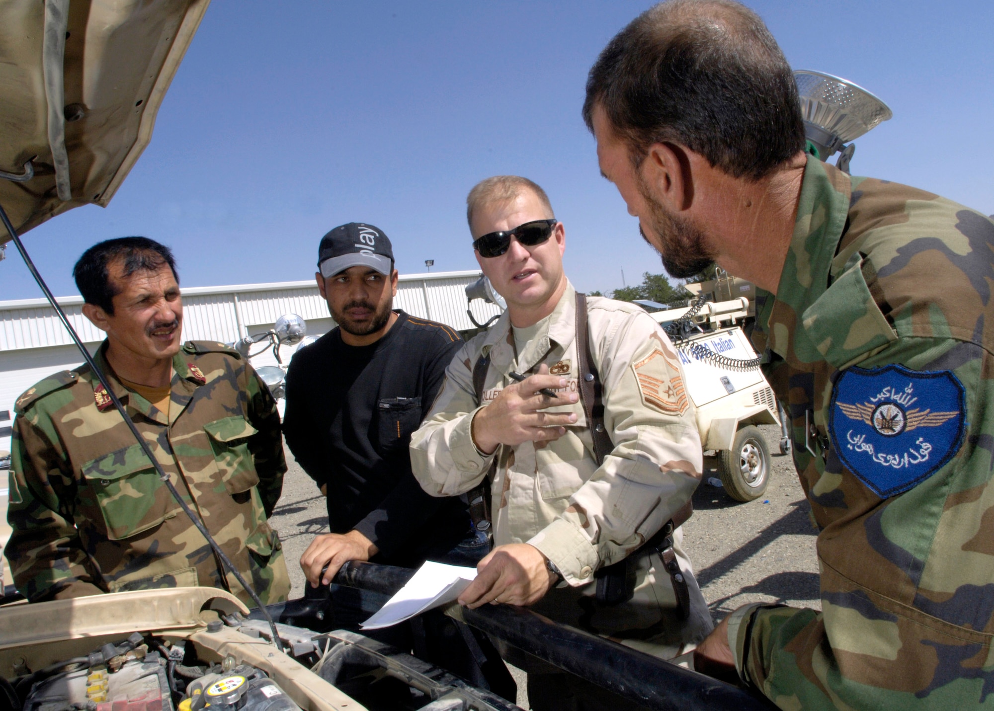 Master Sgt. Michael Stoller mentors Afghan National Army air corps vehicle maintainers July 25 at Kabul International Airport in Afghanistan.  Sergeant Stoller, a vehicle maintenance craftsman deployed from Eielson Air Force Base, Alaska, is assigned to the Combined Security Transition Command-Afghanistan with headquarters on Camp Eggers, Kabul, Afghanistan. (U.S. Air Force photo/Master Sgt. Jim Varhegyi)