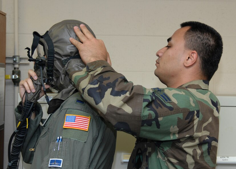 Airman 1st Class Claude Young, 60th Operations Support Squadron, tightens the straps on a gas mask for 1st Lt. James Slayton during the recent exercise at Travis. Airman Young was in charge of properly fitting the flight crew for their gas masks. (U.S. Air Force photo/Laura Fentress)