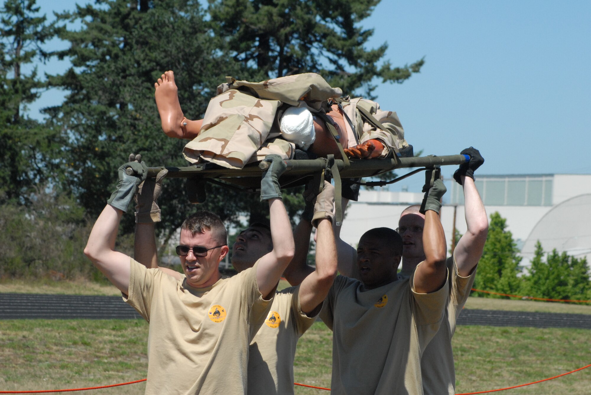 Members of the 2007 Pope Rodeo aeromedical evacuation team, Senior Airman Joseph Morgan, Senior Airman Marcello Mennone, Staff Sgt. Vincent Bland and Capt. Nathan Ferguson perform a four man litter carry during the AE challenge course July 25 at McChord Air Force Base, Wash. The team, led by Capt. Amy Crow, also had to run a mile and a half, perform push ups, sit ups and provide initial medical support to two dummy patients. (U.S. Air Force photo/Staff Sgt. Jon LaDue)
