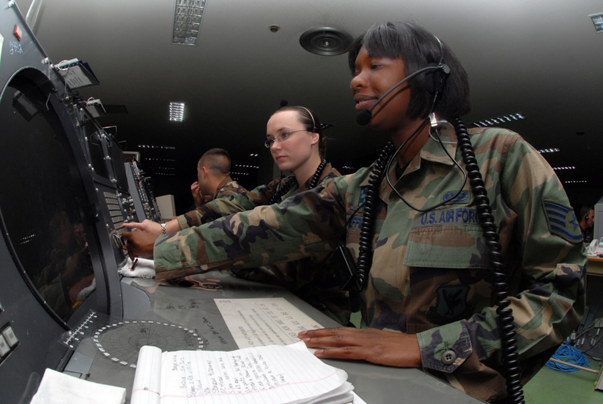 Staff Sgt. Crystal Sheffield, weapons director, and Airman 1st Class Amber Hoedebeck, weapons director technician, 623rd Air Control Flight, on the job at Naha Air Base, Japan. They control the mission by using a Base Air Defense Ground Environment system (BADGE), providing command and control over aircraft with a 360-degree radius. They communicate with pilots, providing time-critical information in order to accomplish the mission. U.S. Air Force/Staff Sgt. Steven Nabor