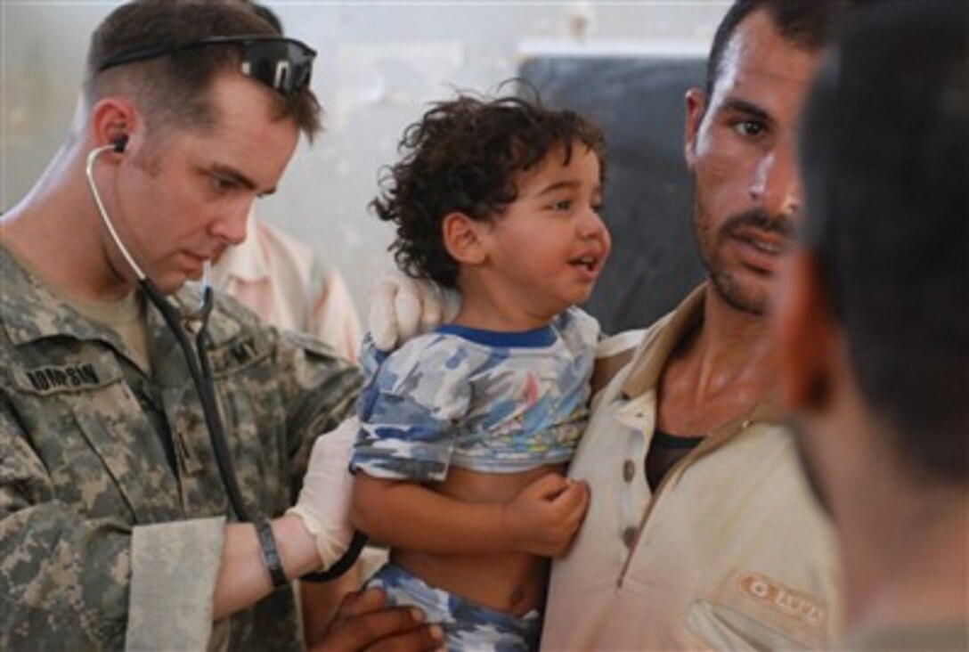 1st Lt. Shawn M. Thompson, battalion physician assistant, 1st Battalion, 15th Infantry Regiment, 3rd Heavy Brigade Combat Team, 3rd Infantry Division, checks an Iraqi boy’s breathing, July 28, 2007, in Wahida, Iraq.
