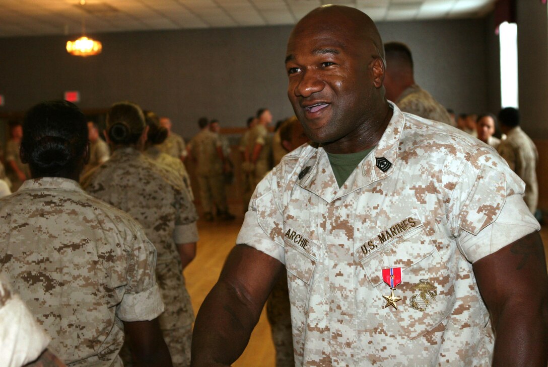 First Sgt. Paul T. Archie, 2nd Medical Battalion sergeant major, shakes the hands of the Marines and sailors of 2nd Medical Battalion after his Bronze Star ceremony here, July 30.  Archie was awarded a Bronze Star Medal with the Combat Distinguishing Device for his concerned leadership, intense work ethic and personal fortitude, while deployed with Weapons Company, 2nd Battalion, 8th Marine Regiment.