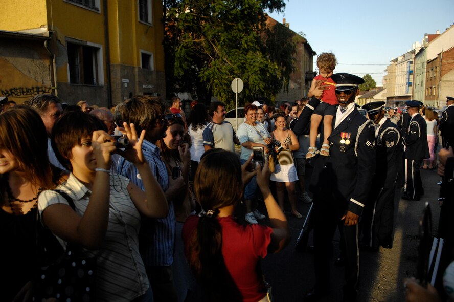 Senior Airman Jermaine James, a member of the U.S. Air Force Honor Guard Drill Team, steadies a Hungarian child on his shoulder as parents take a picture following the Drill Team performamce in Miskolc City, Hungary 28 July, 2007.  The Drill Team, the traveling component of the Air Force Honor Guard, is touring five US installations across three countries throughout central Europe this week. The Drill Team tours U.S. Air Force bases/events world wide showcasing the precision of the U.S. Air Force to recruit, retain and inspire Airmen for the U.S. Air Force mission. (U.S. Air Force Photo by Senior Airman Daniel R. DeCook)(Released)