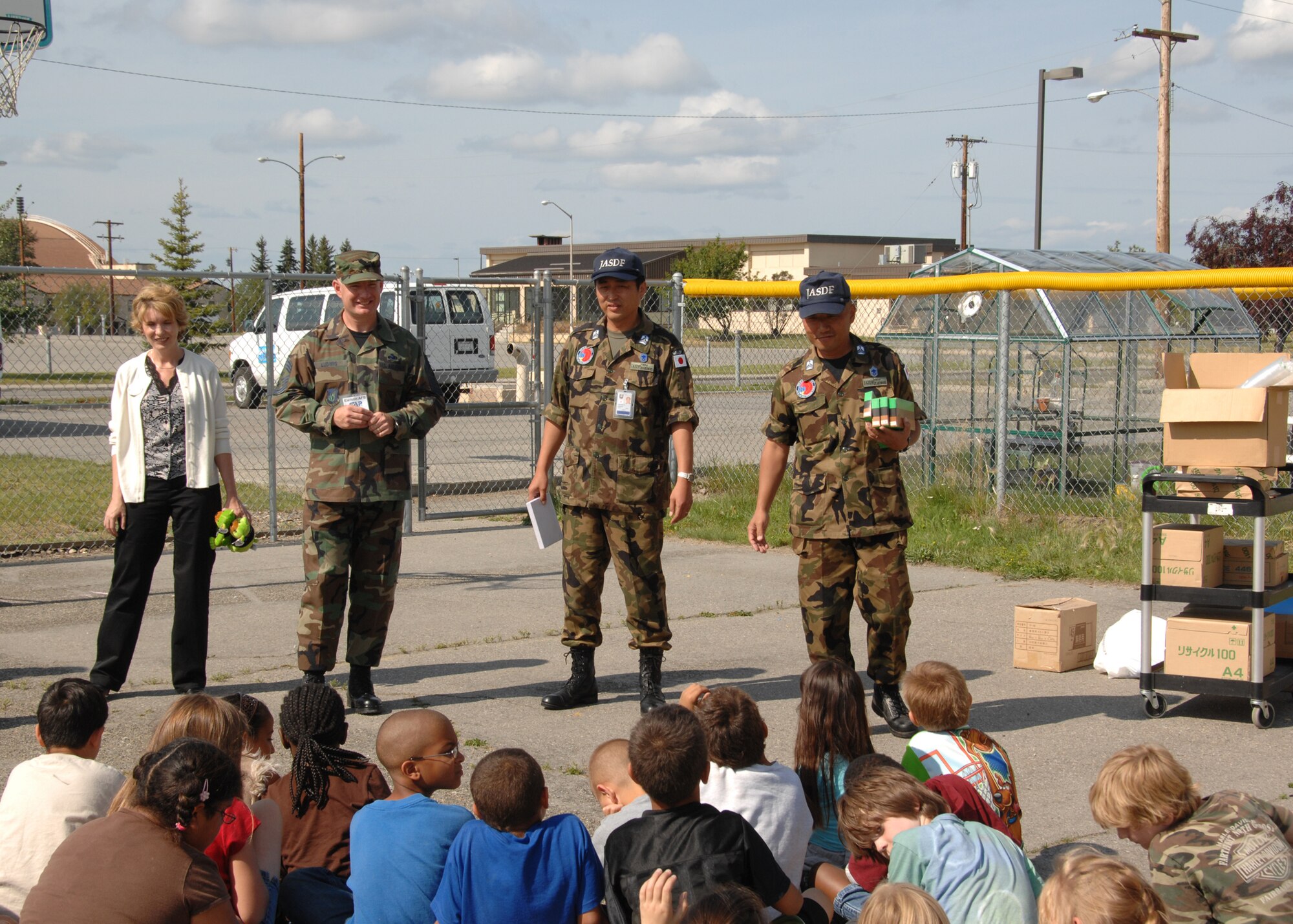 EIELSON AIR FORCE BASE, Alaska--Tammy Jacobs, school-aged program director, Chief Master Sgt. Stephen Ludwig, 354th Fighter Wing command chief, and Chiefs Sakamoto and Akimoto of the Japanese Self Defense Air Force answer children's questions about Japan after the JASDAF Chiefs gave the program all their unused office supplies July 30. JASDAF decided to lighten their load travelling back home by donating all unused supplies to the children for school. (Photo by Glyn Gardner)