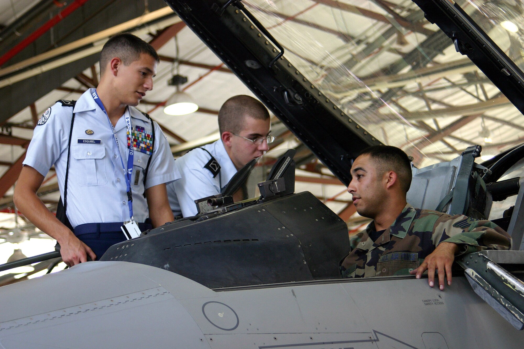 Air Force Junior ROTC Cadets Kyle Esquibel and Daniel Phalin look inside the cockpit of an F-16 Fighting Falcon as Staff Sgt. Luis Otero explains some of the controls.  Sergeant Otero and the F-16 are from the New Mexico Air National Guard's 150th Fighter Wing at Kirtland Air Force Base, N.M.  Cadets from Junior ROTC units worldwide visited various science and technology centers and several Air Force bases as part of the 2007 Air Force Junior ROTC Aerospace and Technology Honor Camps. Approximately 450 cadets attended one of eight camps this year in New Mexico and Oklahoma.  Currently, there are more than 100,000 cadets in the Air Force Junior ROTC program worldwide. (U.S. Air Force photo/Staff Sgt. Jason Lake) 