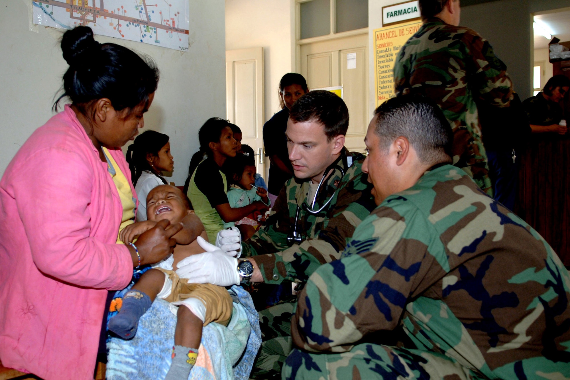 Maj. Scott Shepherd and Senior Airman Felipe Soto treat a 6-month old Bolivian boy who has a fever of 104 degrees during a Medical Readiness Training Exercise in Cobija, Bolivia. The two medics are part of a 30-member medical team in Bolivia treating underserved populations in the country. Major Shephers is assigned to the 152nd Medical Group in Reno, Nev., and Airman Soto is from the 163rd Medical Group. (U.S. Air Force photo)