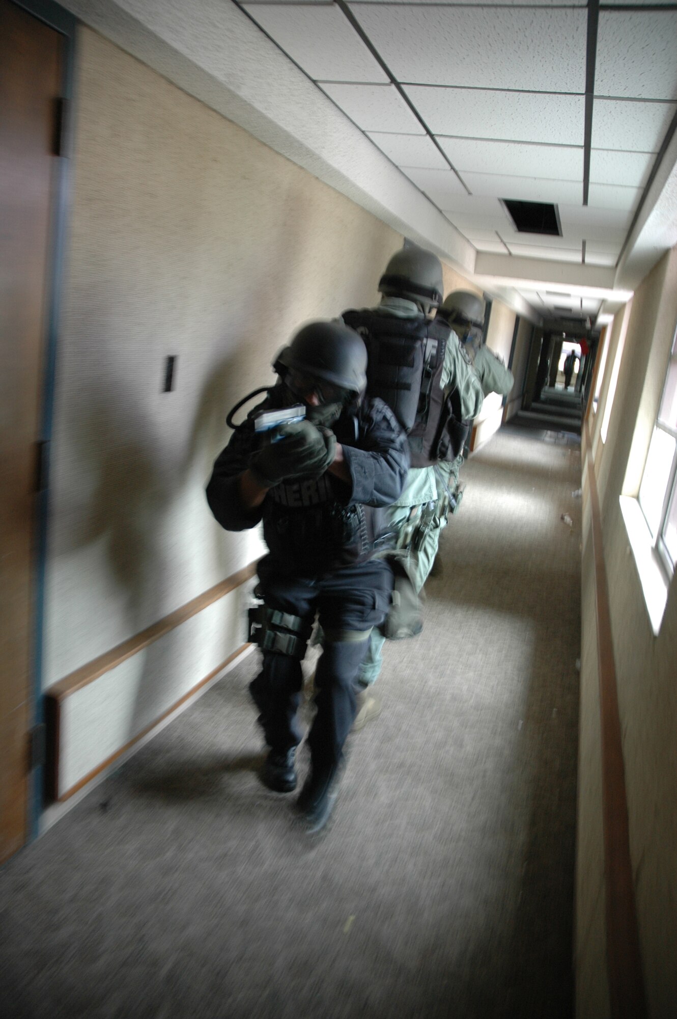 EGLIN AIR FORCE BASE, Fla. -- Members of the Okaloosa County Sheriff's Office Special Response Team tactically work to clear rooms down the hallways inside an Airman dormitory July 31. The deputies used the dormitories scheduled for demolition as a training ground to practice close quarters battle, room clearing and hostage rescue. Airmen from the 96th Security Forces Squadron placed aggressors during the training exercise. (U.S. Air Force photo by Staff Sgt. Mike Meares)  