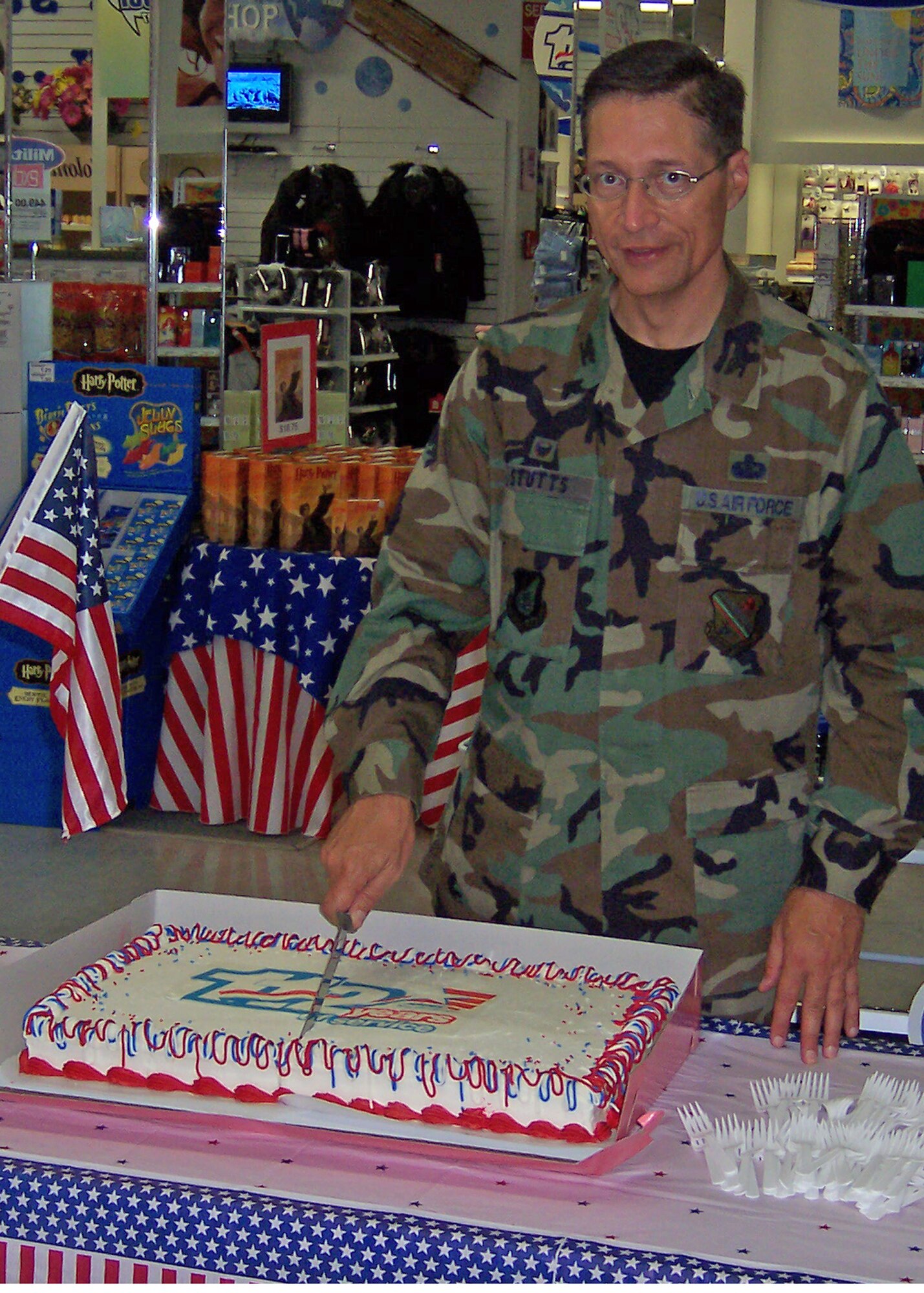 EIELSON AIR FORCE BASE, Alaska--Col. John Stutts, 354th Mission Support Group commander, cuts the cake for AAFES 112th Anniversary July 28 at the base exchange. (Photo by Florence Scott)