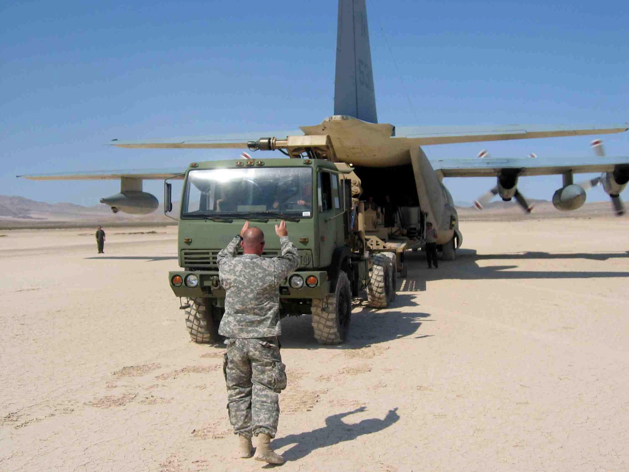 Cargo loaded by Airmen from the 305th Aerial Port Squadron at McGuire Air Force Base, N.J., is removed from a transport aircraft July 30 at an austere airstrip at Fort Irwin, Calif., as part of a joint capabilities technology demonstration by U.S. Transportation Command officials to find greater efficiencies in delivering cargo to the warfighter while reducing the risk servicemembers face on the road during conflict.  The demonstration tested joint modular intermodal distribution concepts that would lead to those greater efficiencies.  (Courtesy photo)