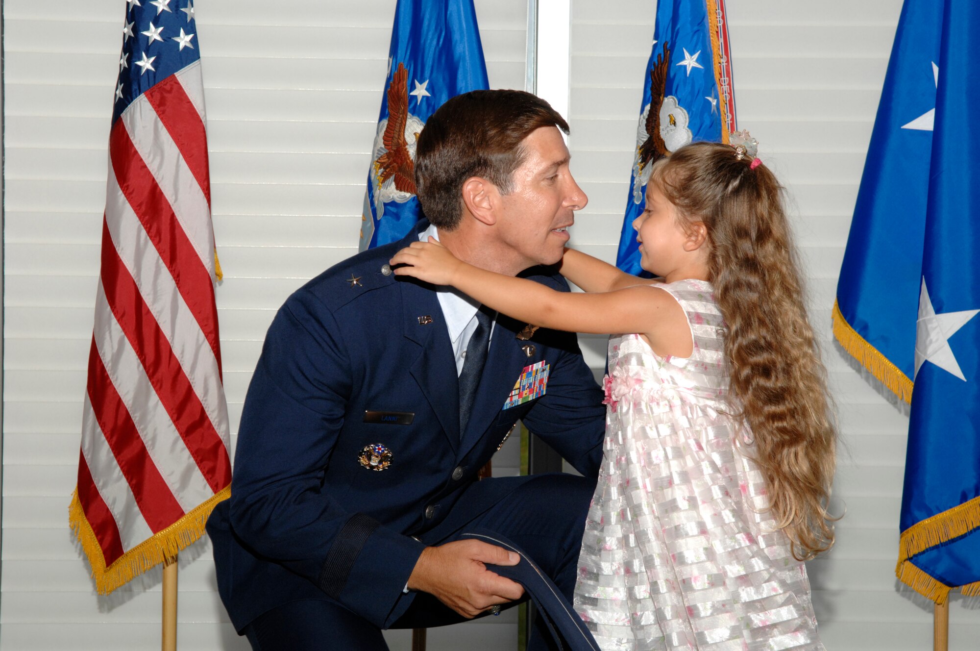 EGLIN AIR FORCE BASE, Fla. -- Brig. Gen. Joseph A. Lanni, Air Armament Center vice commander, get a hug and a kiss form Michaela, his 4-year-old daughter, during his promotion ceremony at the Officers' Club Aug. 27. More than 300 friends and family members from as far away as Washington D.C. and California joined the Lanni family to celebrate the achievement. (U.S. Air Force photo by Craig McDonnell)