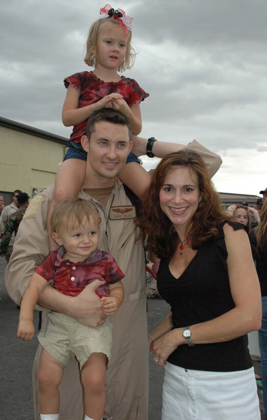 Captain Chris Fields, 34th Bomb Squadron, is reunited with his wife and children after a six-month deployment to Southwest Asia. The deployed Airmen were welcomed home to Ellsworth July 27 by the wing commander, honor guard, local chapter of the Patriot Guard Riders, squadron commanders, chiefs and other well wishers. (U.S. Air Force photo by Maj. Karen Roganov)