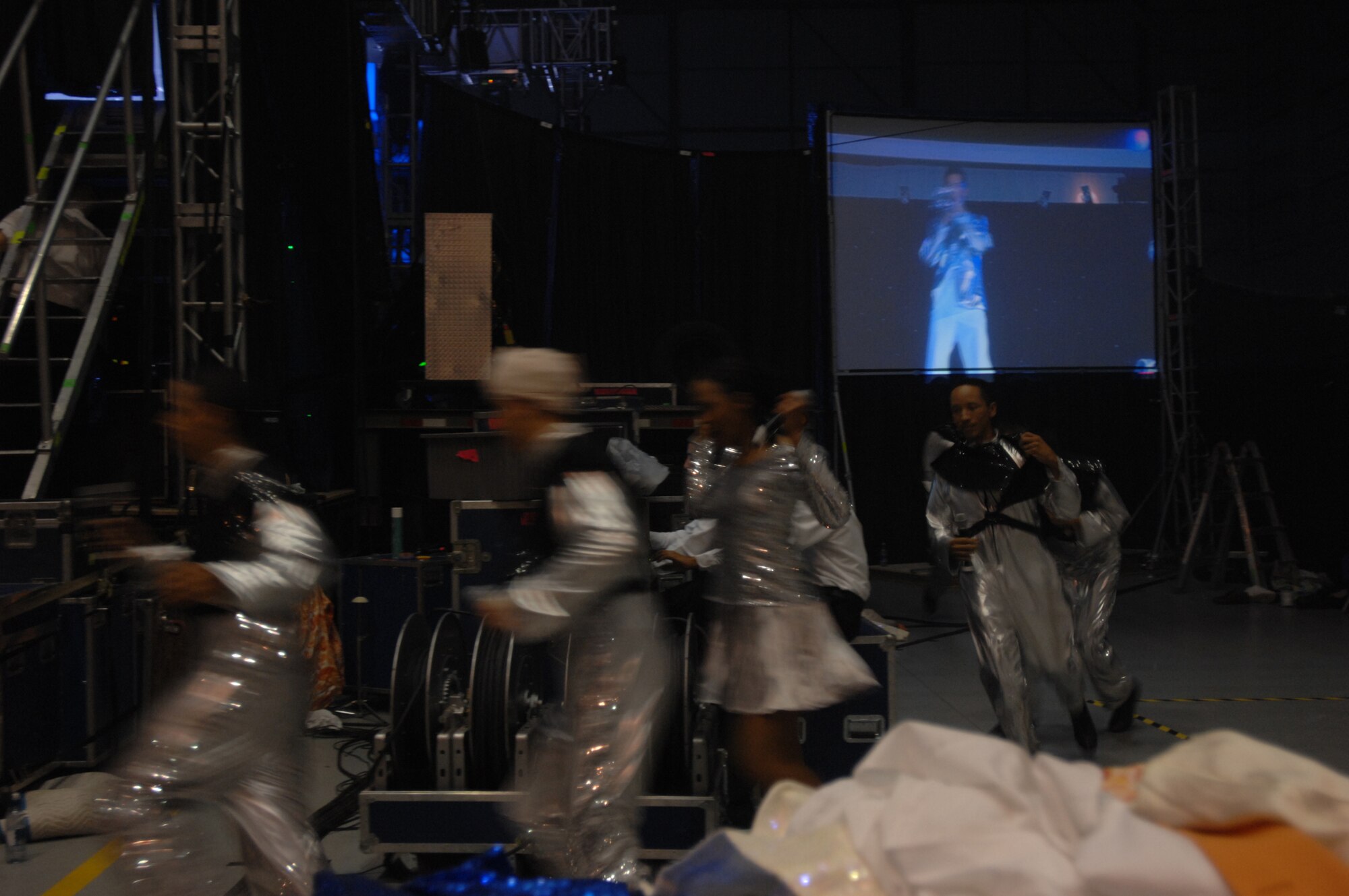 In preparation for the final set of music, several vocalists scramble to the clothing racks for their last wardrobe change of the evening during the RAF Mildenhall performance, July 25, 2007. (U.S. Air Force photo by Tracy L. DeMarco)