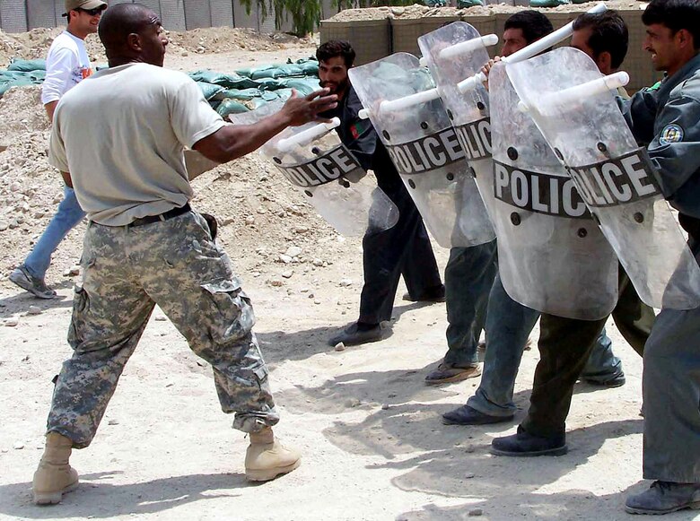 Tech. Sgt. Drayton Denson teaches riot control techniques to a recent class of Afghanistan national police students at Forward Operating Base Mehtar Lam, Afghanistan. The students participated in a six-day course and spent more than 30 hours, both in and out of the classroom, with their Air Force instructors. Sergeant Denson is the Mehtar Lam Provincial Reconstruction Team Police Tactics and Refresher Training superintendent. (U.S. Air Force photo) 