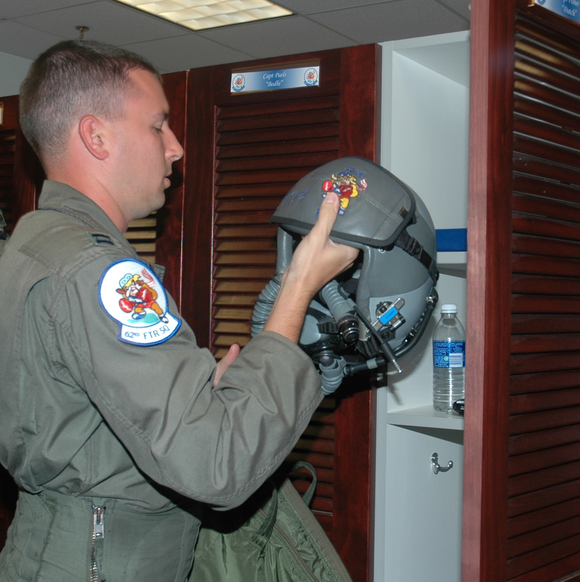 Capt. Kevin Fisher, 62nd Fighter Squadron D-flight commander, suits up before flying “red air” in an F-16 against an F-22.  The captain deployed from Luke AFB, Ariz., on July 23 to participate in dissimilar aircraft training at Tyndall. (U.S. Air Force photo/Staff Sgt. Vesta Anderson)