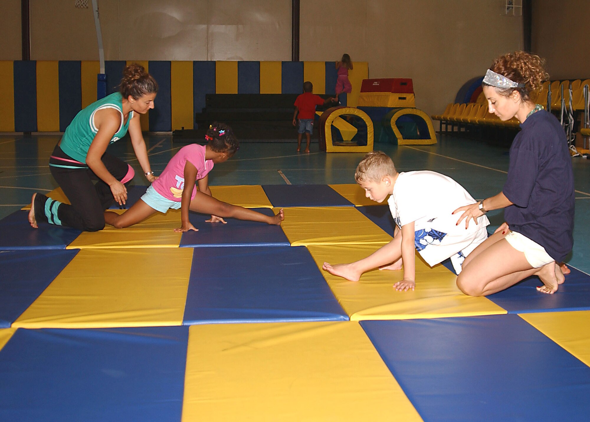 Deniz and Seniz Unalmis teach gymnastics to Kiana Dove and Kristopher Ryan at the Incirlik Youth Center gymnastics instructional class on July 24.  (U. S. Air Force photo by Tech. Sgt. Patrick Hyde)                          