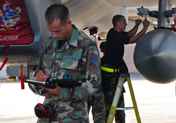 Senior Airman Zane Mays from the weapons standardization flight evaluates the Weapons Load Crew of the Quarter competion July 20 here. Airman Zane is assigned to the 18th Maintenance Operations Squadron. The 44th Aircraft Maintenance Unit won the competition. (U.S. Air Force photo/Airman 1st Class Sheila deVera) 

