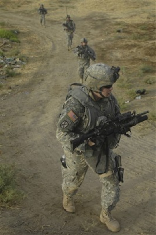 Soldiers from the U.S. Army's 10th Mountain Division patrol in a single file as they perform a route clearance mission along Route Tampa in southwest Baghdad, Iraq, on July 28, 2007.  The soldiers are with the 3rd Platoon, Alpha Company, 2nd Battalion, 14th Infantry Regiment, 2nd Brigade Combat Team, 10th Mountain Division out of Fort Drum, N.Y.  