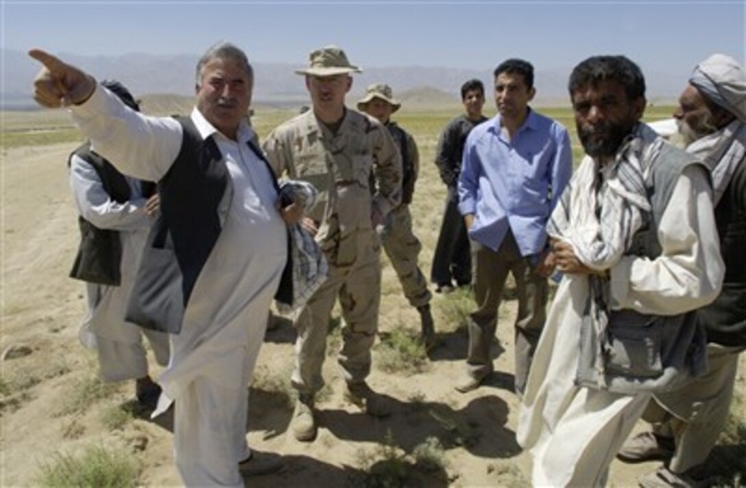 U.S. Navy Capt. James Fisher, the chaplain for Combined Security Transition Command-Afghanistan, listens as Mohammad Khan, left, the assistant director of a relief agency, explains the most pressing needs at an internal displaced persons camp outside of Kabul, Afghanistan, July 27, 2007. 