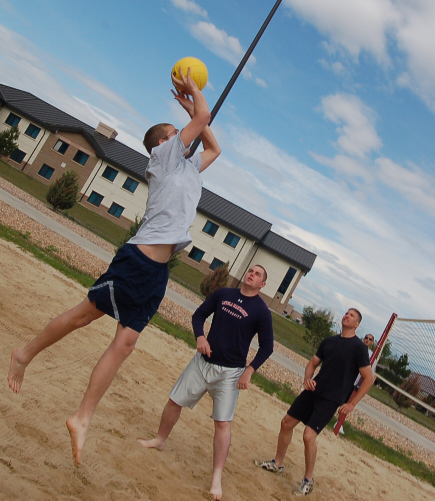 BUCKLEY AIR FORCE BASE, Colo. -- Airman 1st Class John Parsons, from the 460th Comptroller Squadron, lays the ball up for his team in a volleyball game during the Buckley Sports, Field and Safety Day June 1. Sports events for the day included a 10 kilometer bike race, basketball, mushball, ultimate frisbee, sand volleyball, tennis, a 400 meter run, a 100 meter dash, a tug of war and a 5 kilometer run/walk. The event marked the beginning of the 101 Critical Days of Summer. (U.S. Air Force photo by Senior Airman Jacque Lickteig)