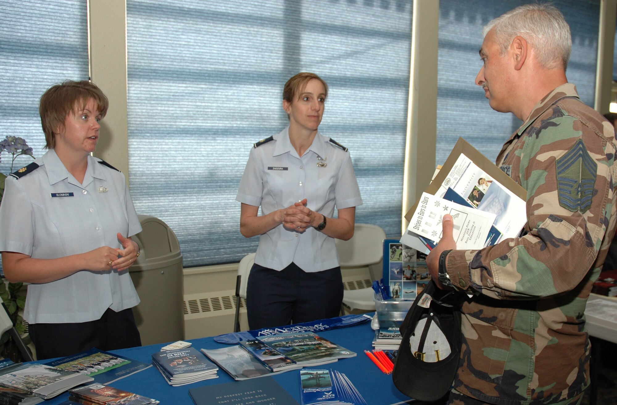 MOUNTAIN HOME AIR FORCE BASE, Idaho -- From left, Maj. Nicole Slominski and Maj. Robin Zadzora, the base’s admissions liaison officers for the Air Force Academy, discuss commissioning programs with Chief Master Sgt. Giovanni Catanese, during the base’s annual education fair June 1 at the Community Activities Center here. Chief Catanese, 366th Logistics Readiness Squadron, was one of dozens of military members and spouses who visited the fair to discuss education opportunities with representatives from various colleges and universities catering to those in the armed forces. Representatives from the Department of Education’s Troops to Teachers program were also on hand to help people learn how to transfer from active duty service into the civilian education sector. (U.S. Air Force photo/Master Sgt. Brian S. Orban)