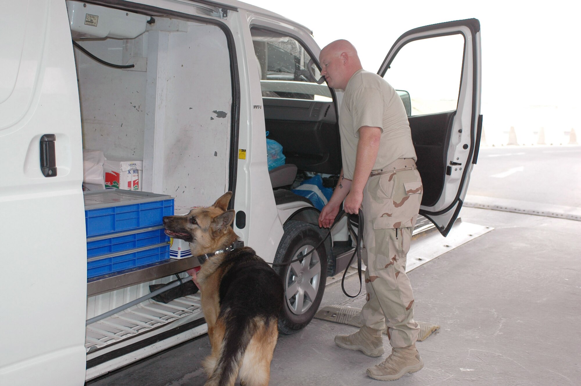 Staff Sgt. Scott Yeager and his dog, Stony, inspect a vehicle at the search pit in Southwest Asia. Sergeant Yeager and Stony work together on a daily basis searching vehicles for improvised explosive devices and vehicle borne explosive devices. (U.S. Air Force photo/Staff Sgt. Cassandra Locke)