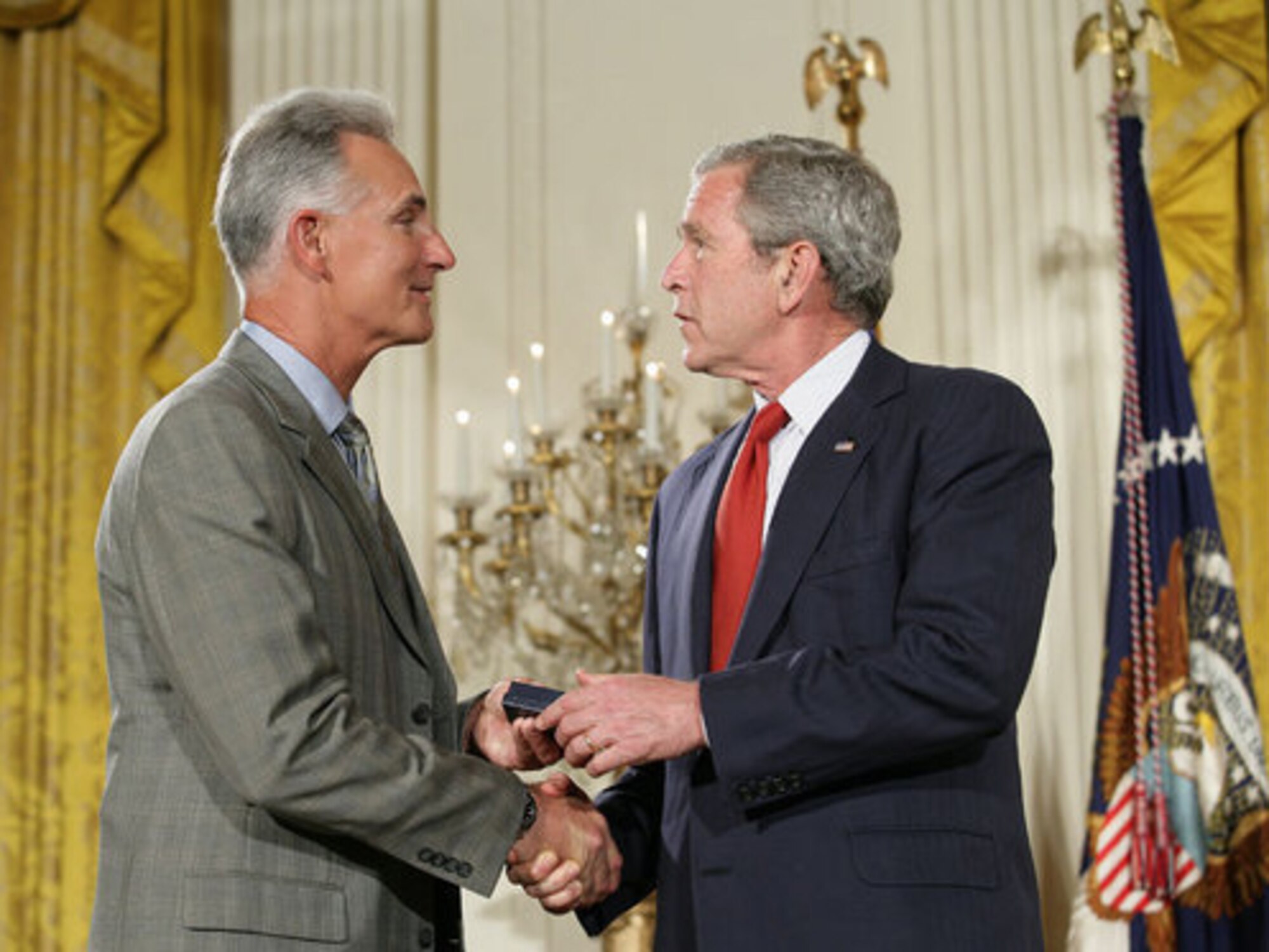 President George W. Bush congratulates military spouse Michael Winton of Wright-Patterson Air Force Base, Ohio, as Mr. Winton is presented with the President’s Volunteer Service Award. The ceremony occurred May 11 in the East Room of the White House during a celebration of Military Spouse Day. (White House photo by Eric Draper)
