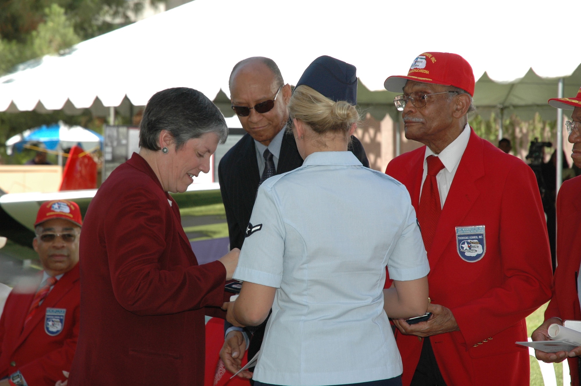 Arizona Governor Janet Napolitano presents the Congressional Gold Medal to Lt. Col. (ret.) Luke Weathers (in red) during a ceremony at the state capitol May 24. Airmen from Luke also participated in the historic ceremony honoring these Airmen of World War II fame. Photo by Tech. Sgt. Susan Stout