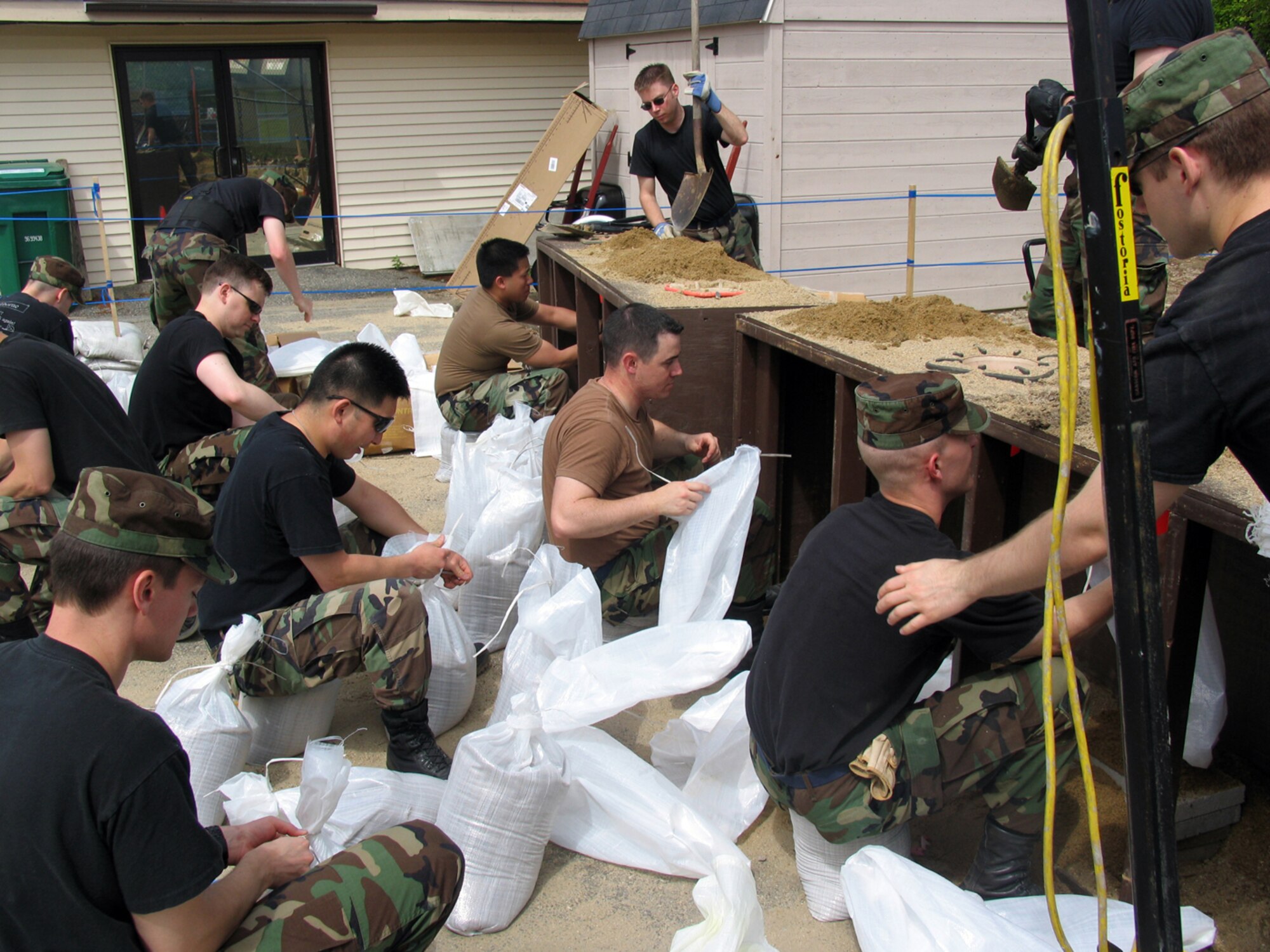 Members of the Camp Patriot set-up team fill  sandbags May 23 under an unseasonably warm May sun. The team filled more than 100 sandbags to be used to protect Camp Patriot tents against simulated attacks. The camp is used in Base Readiness Exercises as a simulated deployed location. Hanscom has been holding monthly BREs since January in preparation for the base’s Operational Readiness Inspection, which will run June 9 to 19. (US Air Force photo by 1Lt. Lisa Spilinek)