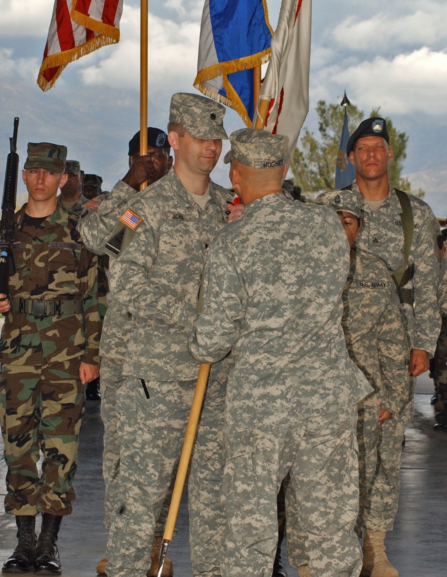 SOTO CANO AIR BASE, Honduras – Army Col. Christopher Hughes, Joint Task Force-Bravo commander, passes the Army Forces guidon to Army Lt. Col. Gregory Jicha, who took over leadership from Army Lt. Col Ernesto Sirvas during the ceremony at the Soto Cano Air Base fire station June 1.  This change of command ceremony is the first of five major supporting command leadership changes slated for this month.  (Department of Defense photo/Martin Chahin)