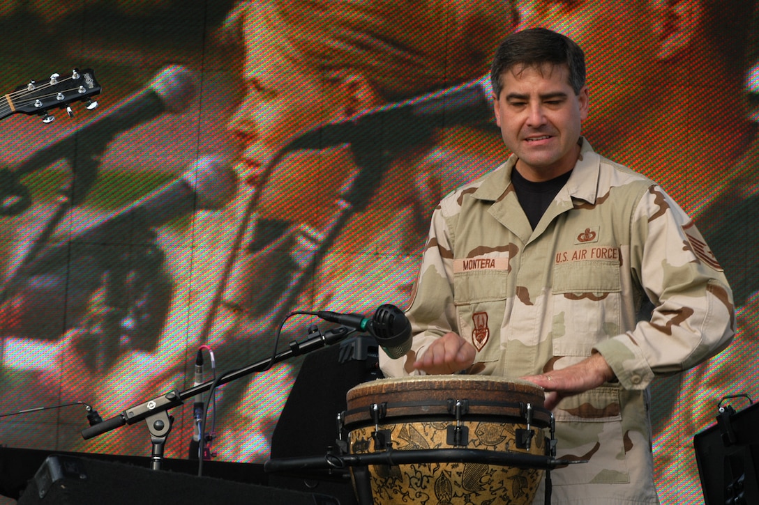 Master Sgt Douglas Montera leads Night Wing during the opening of the USAF Heartland of America Band's 2006 Tattoo held at the Offutt AFB parade field.  On the screen behind him are Night Wing's vocalists, Tech Sgt Lara Murdzia and Staff Sgt Clint Whitney