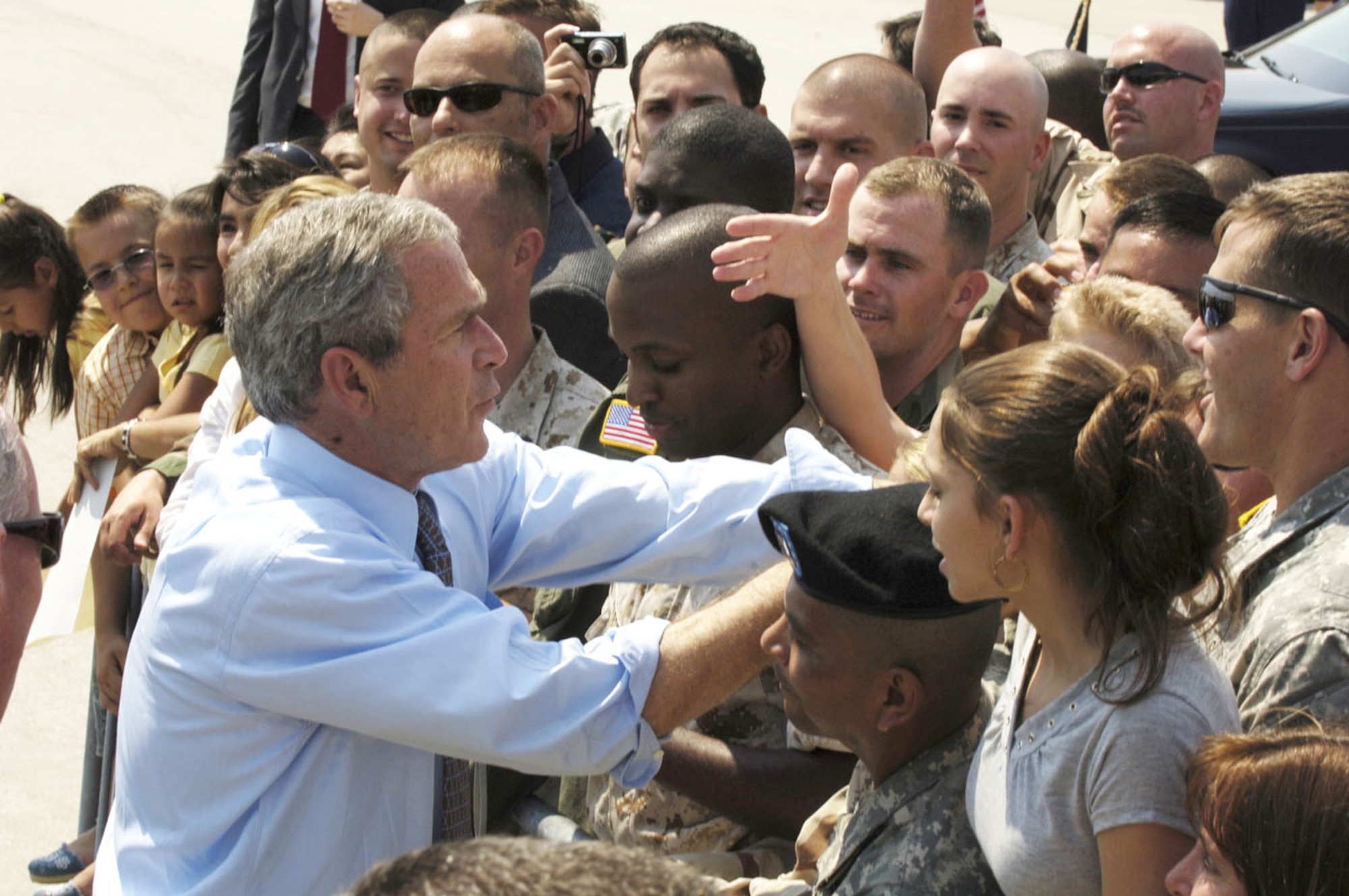 President George W. Bush wades into an enthusiastic crowd on the flightline May 1, shortly before taking off in Air Force One. He visited the base to deliver a message to U.S. serveicemembers and Coalition members, thanking them for their efforts in the Global War on Terrorism. (Air Force Photo by Airman 1st Class Stephanie Wade)