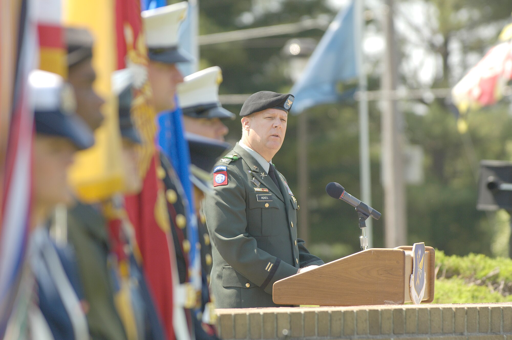 Left, Col. Dave McNeil, Fort Dix installation commander, speaks to the crowd at the 2007 Parade of Wreaths Ceremony as the Joint Honor Guard stands at parade rest.