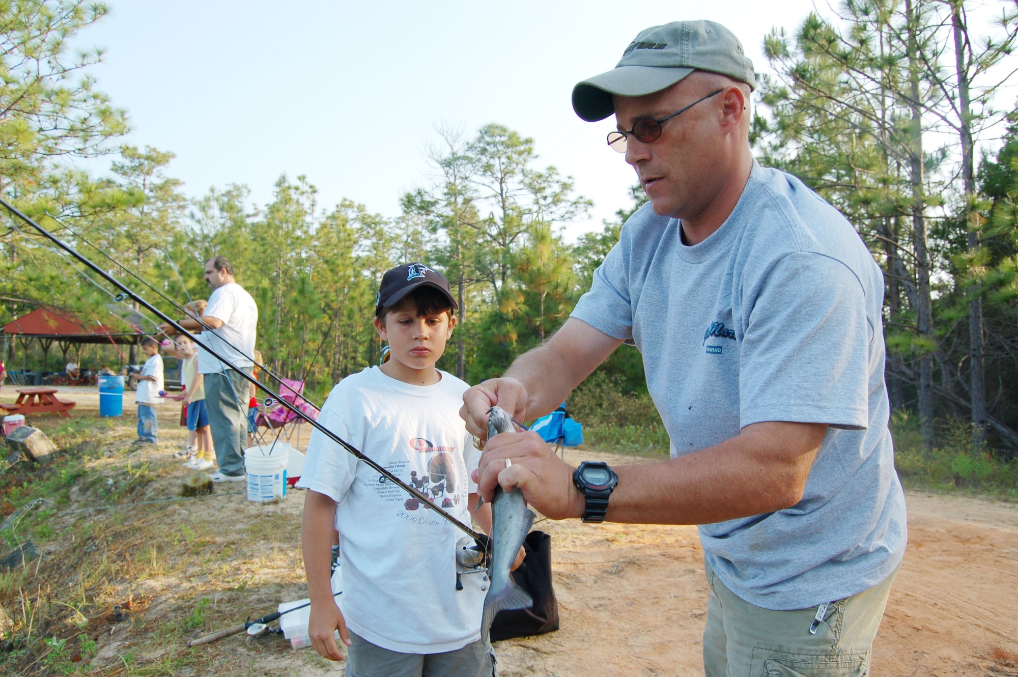 EGLIN AIR FORCE BASE, Fla. -- U.S. Army Lt. Col. Lee Sikes, 6th Ranger Training Battalion commander, removes a hook from a fish for his son Blake during the Youth Fishing Rodeo event May 26. The event was held on Prisoner Pond, an approximately five acre lake at the 6th Ranger Training Battallion compound. Members of the U.S. Fish and Wildlife Service stocked the pond with approximately 3,000 channel catfish that were provided by the USFWS Welaka National Fish Hatchery in preparation for the Rodeo event. Additionally, Jackson Guard purchased approximately 1,000 pounds of catfish that was added to the pond before the event. (U.S. Air Force photo by Jerron Barnett)