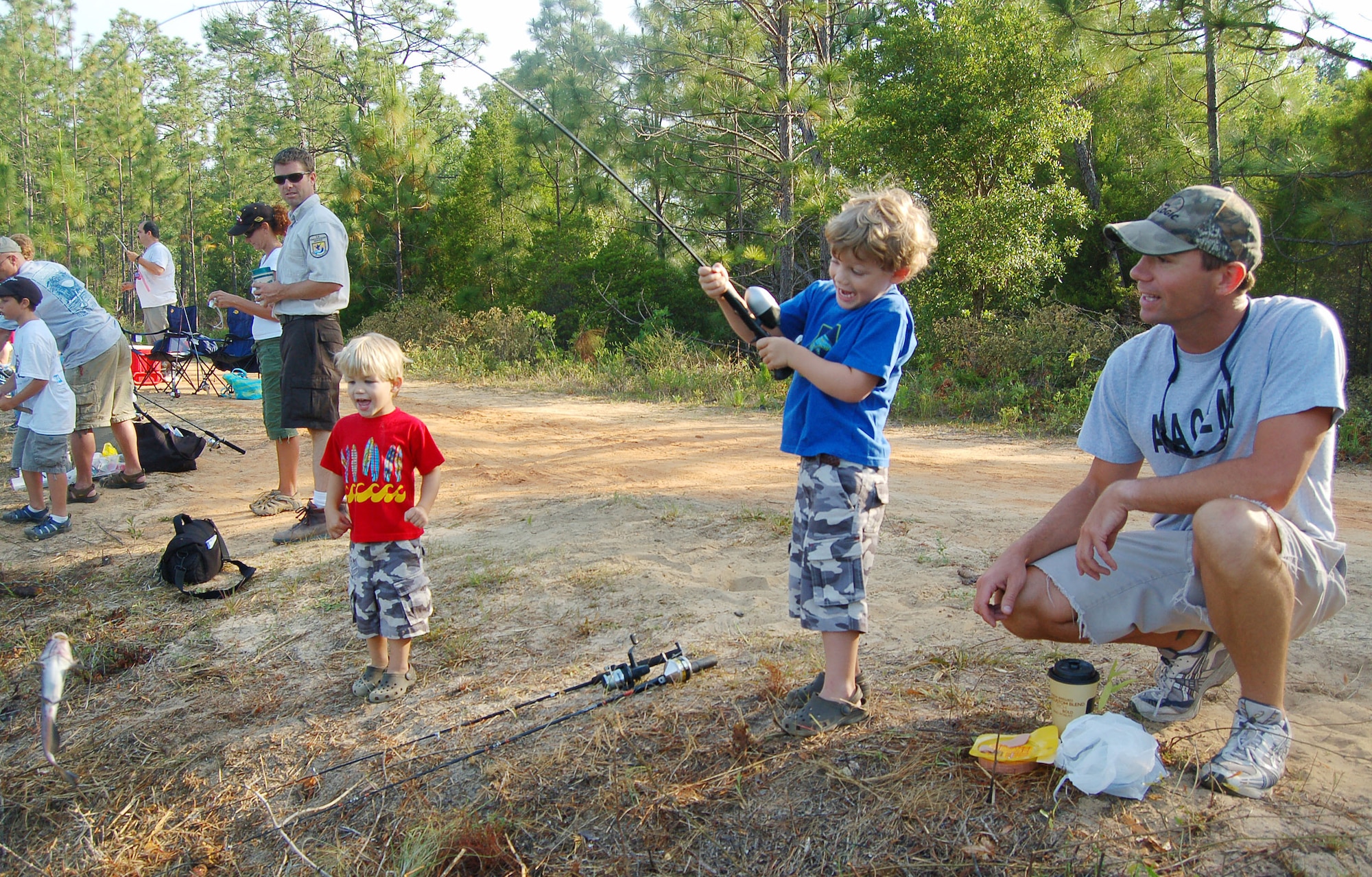 EGLIN AIR FORCE BASE, Fla. -- Mike Nunley and his son Parker encourage brother Mason as he reels in a catfish during the Eglin Youth Fishing Rodeo at Prisoner Pond May 26.  "My boys had a wonderful time and were very excited to be fishing with other children in such a beautiful place," said Mr. Nunley, a Science Applications International Corporation marine and environmental scientist. "They talked about fishing the rest of the day." The event was held on Prisoner Pond, an approximately five acre lake at the 6th Ranger Training Battallion compound. Members of the U.S. Fish and Wildlife Service stocked the pond with approximately 3,000 channel catfish that were provided by the USFWS Welaka National Fish Hatchery in preparation for the Rodeo event. Additionally, Jackson Guard purchased approximately 1,000 pounds of catfish that was added to the pond before the event. (U.S. Air Force photo by Jerron Barnett)