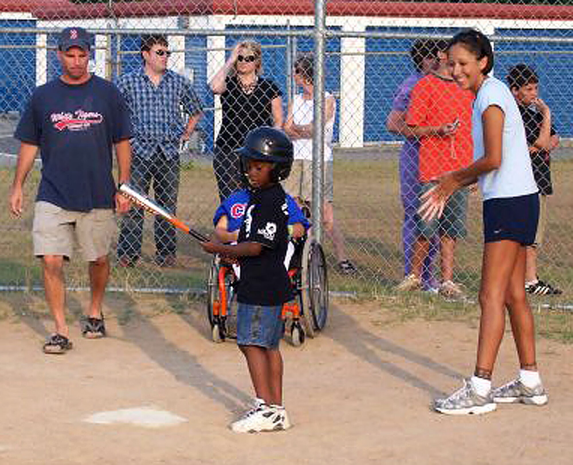 Staff Sgt. Ortega looks on as Jamarco gets ready to hit. The non-profit organization is set up to allow disabled children the chance to round the bases, get some hits, make friends and have fun. (Courtesy Photo)