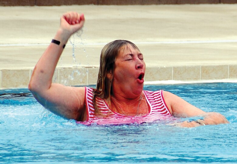 Debra Bastain, the mother of fallen Air Force special tactics officer Capt. Derek Argel, takes an impromptu dive into the pool at the aquatics training facility dedicated in Capt. Argel’s memory. (U.S. Air Force photo by Chief Master Sgt. Gary Emery)