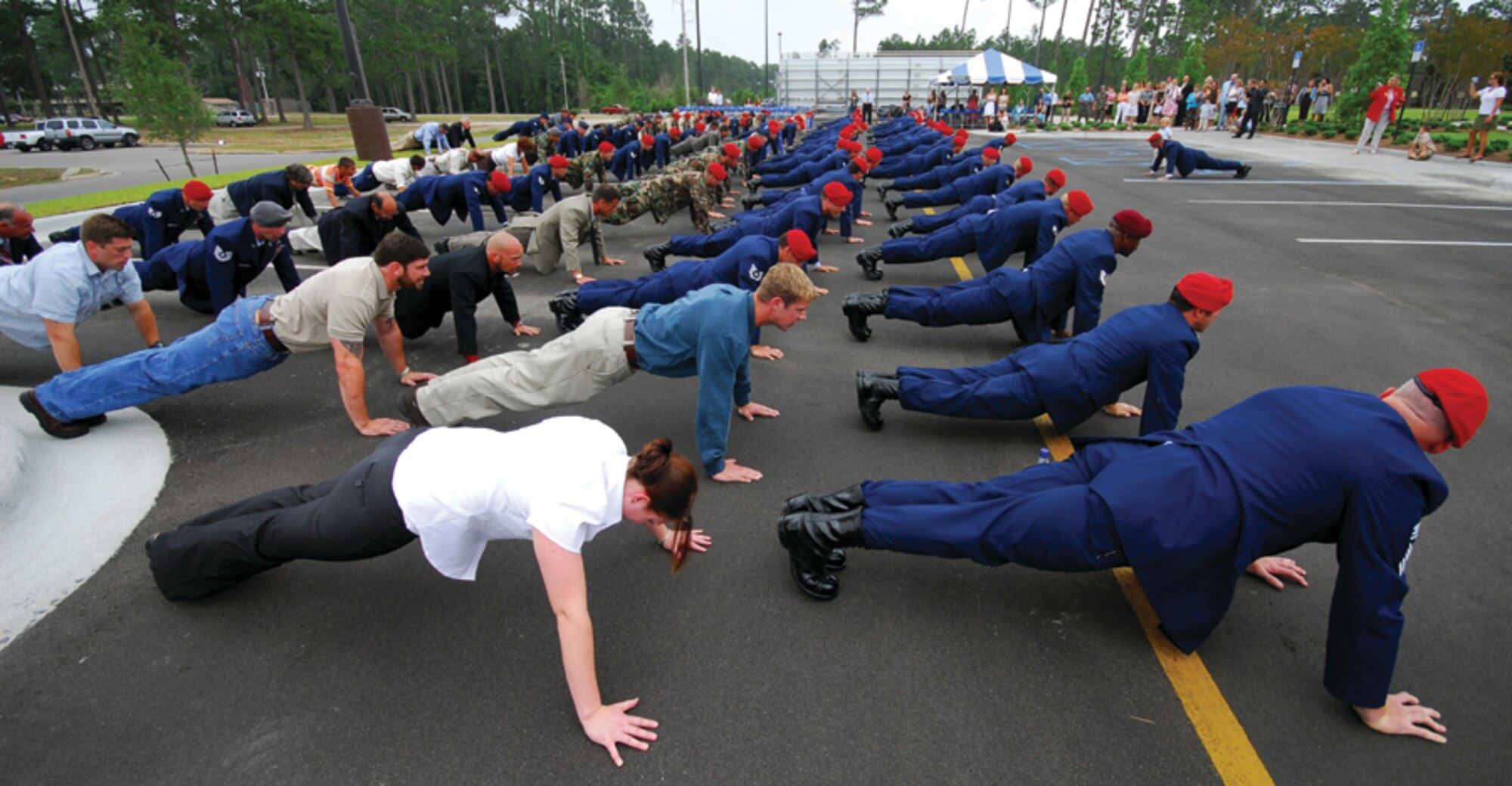 Special tactics Airmen and family members of fallen special tactics warriors join in memorial pushups during the dedication of the Crate Special Tactics Advanced Skills Training Center at Hurlburt Field Wednesday. The center will provide operational training to newly-minted special tactics Airmen.  It is named for Staff Sgt. Casey Crate, a combat controller who lost his life in the crash of an Iraqi air force aircraft in 2005. (U.S. Air Force photo by Chief Master Sgt. Gary Emery)