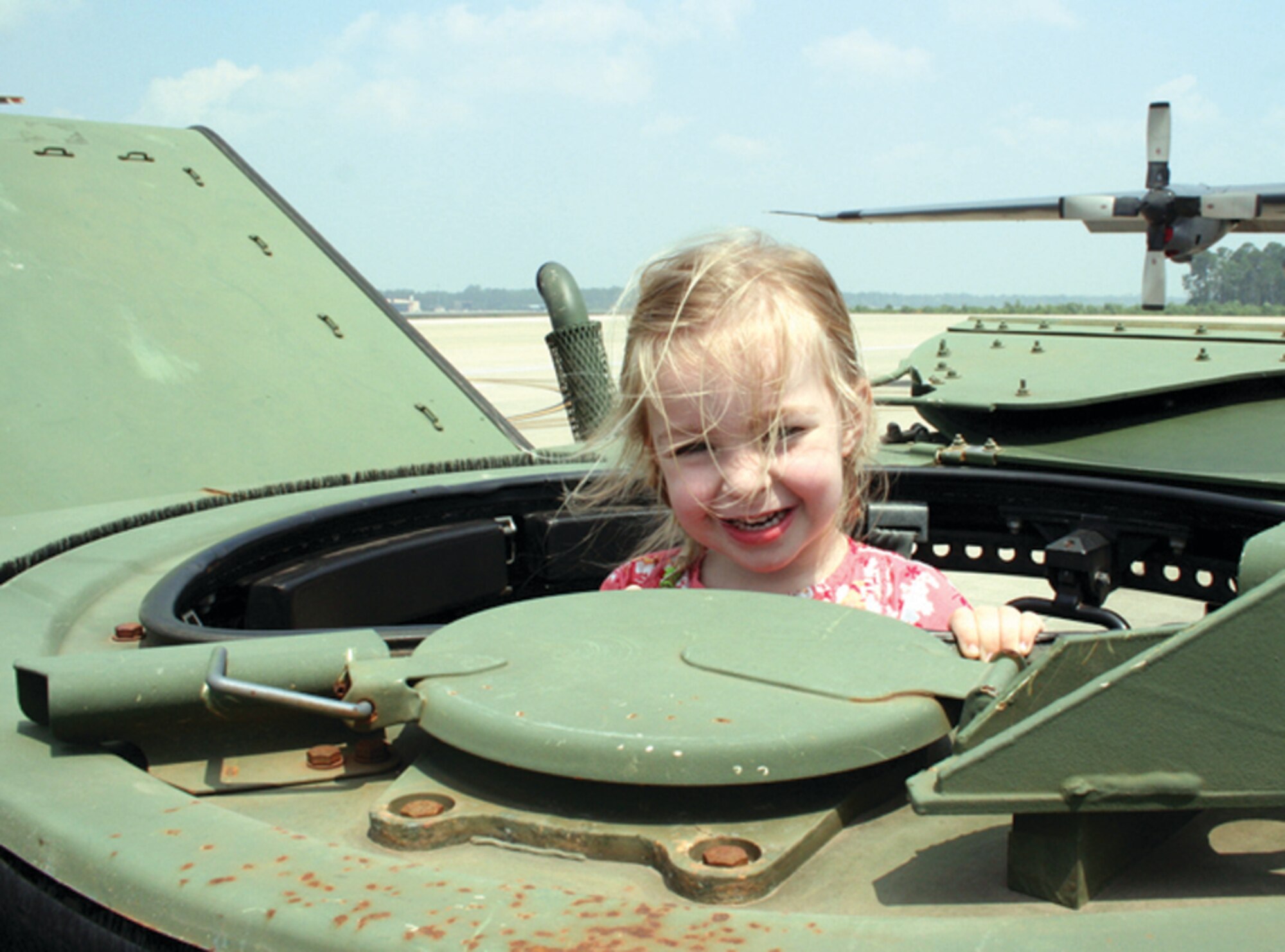 Sophie Van AntWerpen, daughter of Staff Sgt. Cory Van AntWerpen, 1st Special Operations Maintenance Operations Squadron, and Staff Sgt. Annarose Van AntWerpen, 1st Special Operations Security Forces Squadron, enjoys the view from the hatch of a humvee. (U.S. Air Force photo by Jamie Haig)