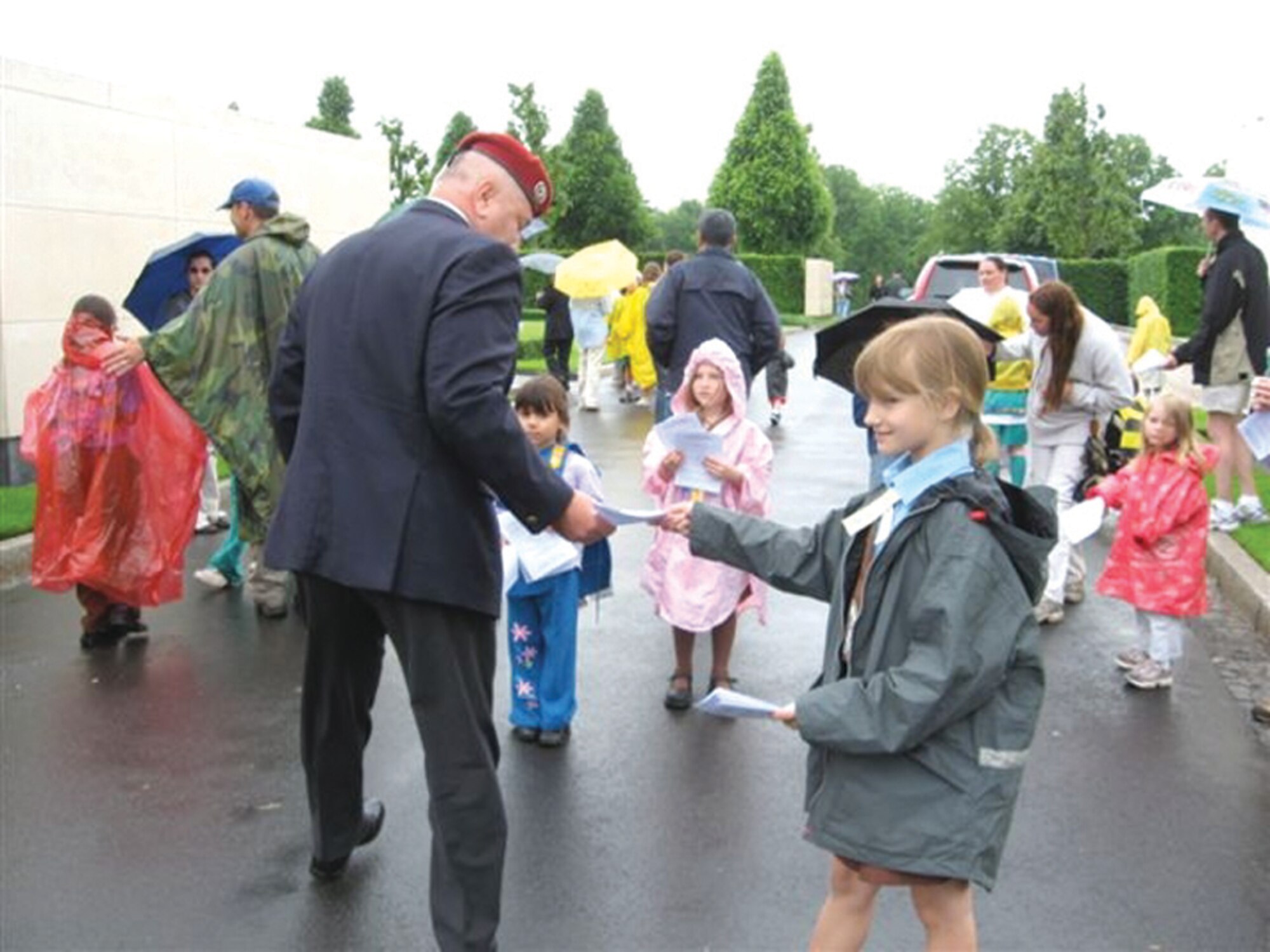 ST. AVOLD, FRANCE --  MaKenna DeMers, a Spangdahlem Air Base Brownie Girl Scout, passes out programs to visitors at a St. Avold ceremony. A group of 25 Scouts from Spangdahlem AB traveled to St. Avold, France, to prepare the cemetery for a Memorial Day ceremony. (Photo by Michelle DeMers)