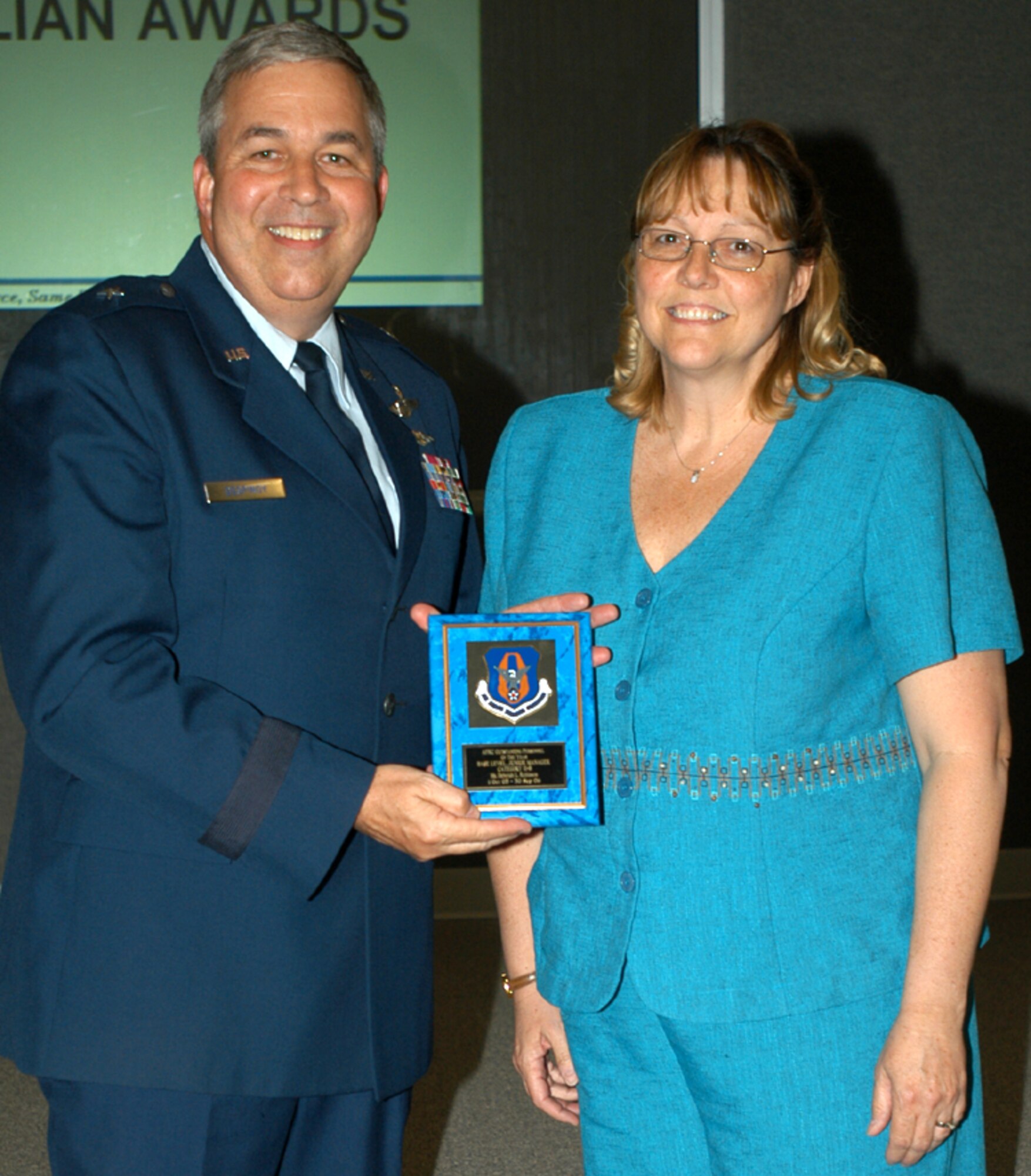 GRISSOM AIR RESERVE BASE, Ind., -- Deborah Robinson, a  human resources assistant with the 434th Military Personnel Flight, receives a plaque for being named the Air Force Reserve Command's Outstanding Basel Level Personnel Manager of the  Year. Presenting the plaque is Brig. Gen. Dean Despinoy, 434th Air Refueling Wing commander. The presentation was made during a special civilian commander's call held recently. (U.S. Air Force photo/Tech. Sgt. Doug Hays)