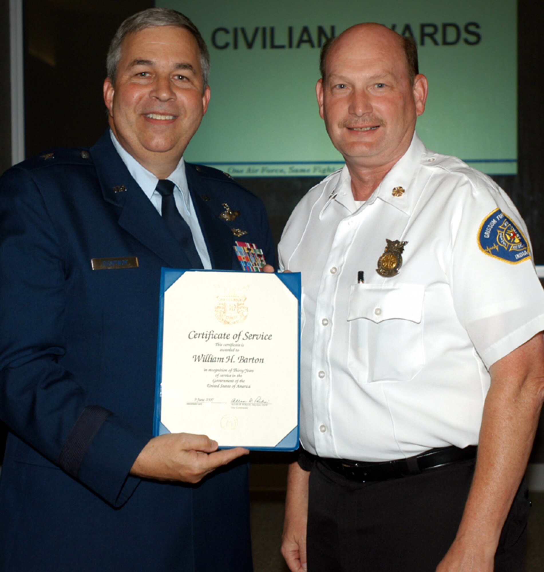 GRISSOM AIR RESERVE BASE, Ind., -- William Barton, right, Grissom's fire chief, receives a pin and certificate marking his 30  years of civil service. Presenting the items is Brig. Gen. Dean Despinoy, 434th Air Refueling Wing commander. The certificate and pin were presented during a special civilian commander's call held recently. (U.S. Air Force photo/Tech. Sgt. Doug Hays)