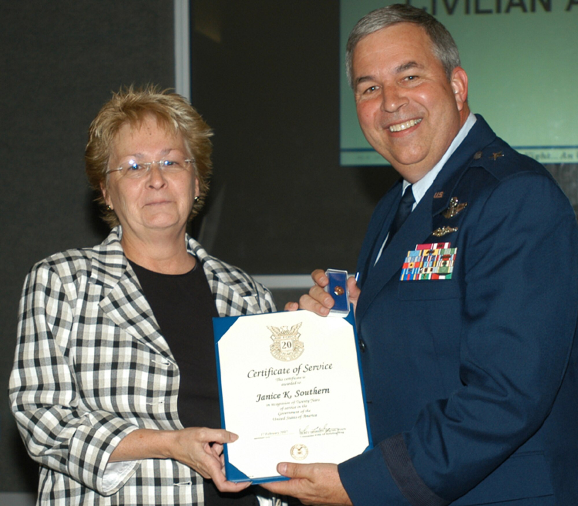 GRISSOM AIR RESERVE BASE, Ind., -- Jan Southern, a civilian personnel specialist, receives a pin and certificate marking her 20 years of civil service. Presenting the certificate is Brig. Gen. Dean Despinoy, 434th Air Refueling Wing commander. The presentation was made during a special civilian commander's call held recently. (U.S. Air Force photo/Tech. Sgt. Doug Hays)