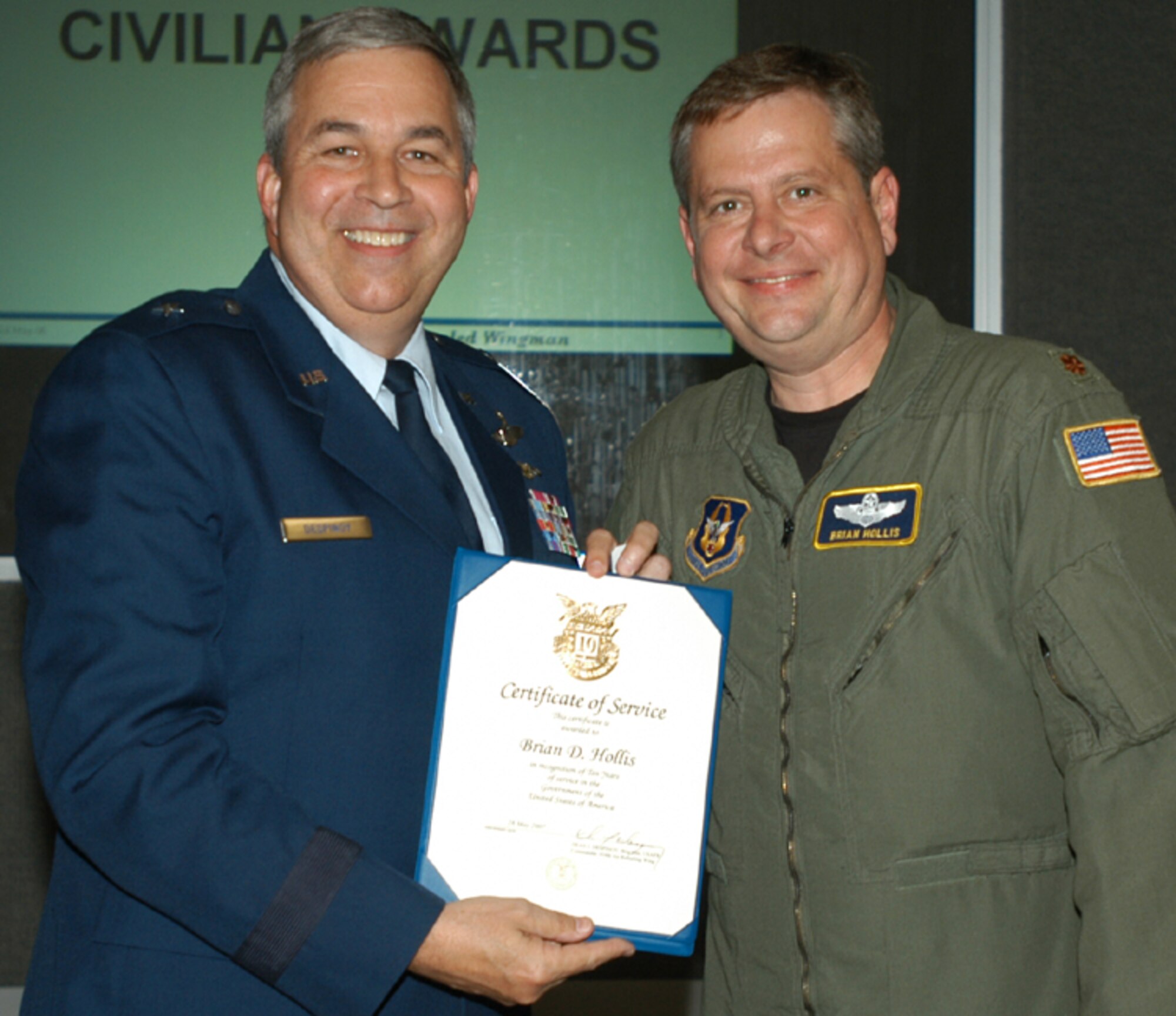 GRISSOM AIR RESERVE BASE, Ind., -- Maj. Brian Hollis, right, 72nd Air Refueling Squadron, receives a pin and certificate marking 10 years of civil service from Brig. Gen. Dean Despinoy, 434th Air Refueling Wing commander. The presentation was made during a special civilian commander's call held recently. (U.S. Air Force photo/Tech. Sgt. Doug Hays)