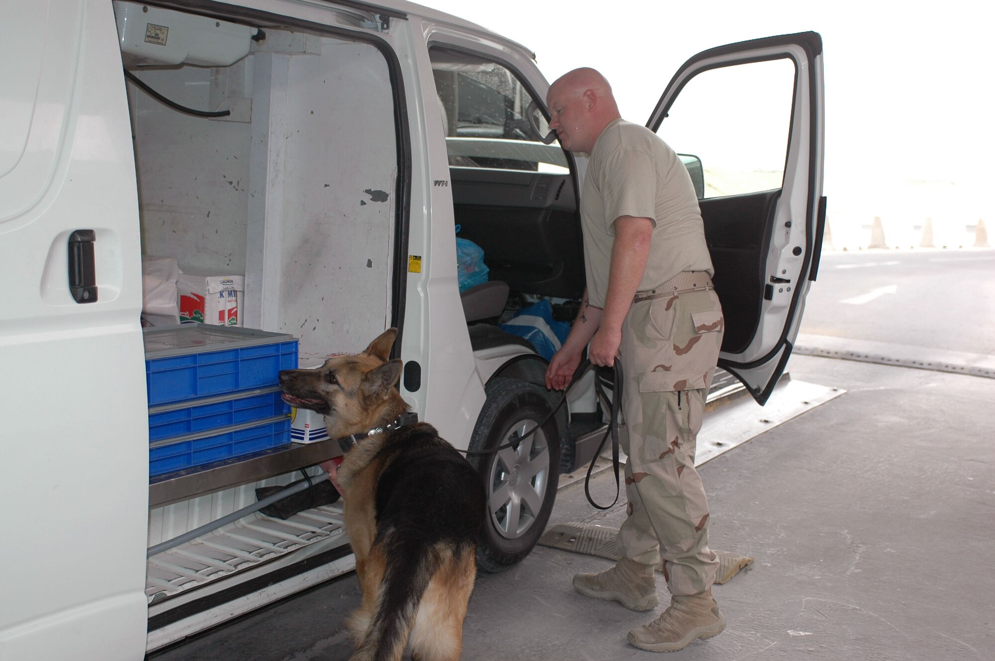 Staff Sgt. Scott Yeager and Military Working Dog Stony, both with the 379th Expeditionary Security Forces Squadron, inspect a vehicle at the search pit. 
