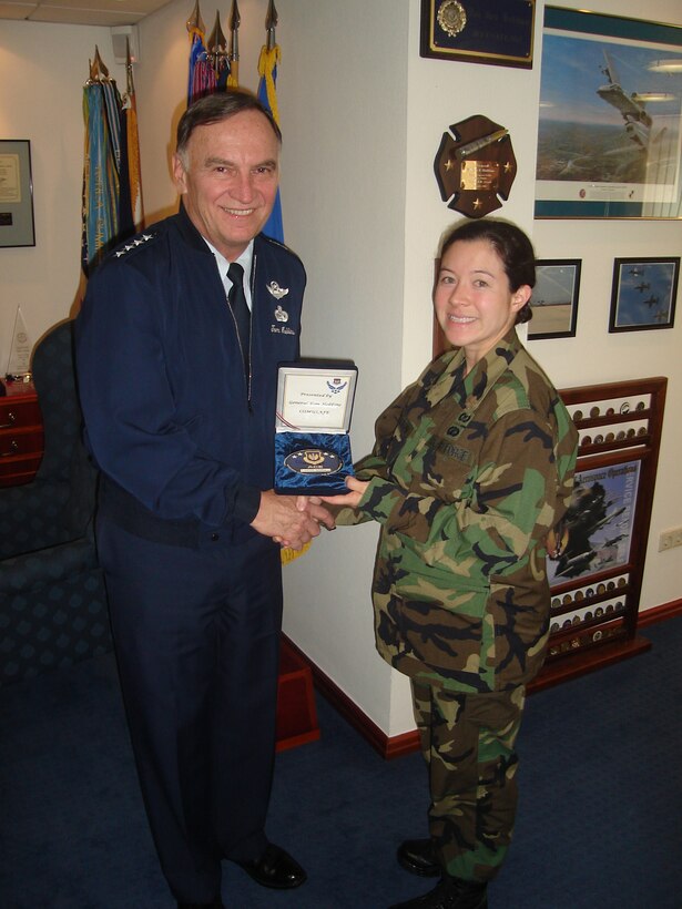 Gen. Tom Hobbins, Commander U.S. Air Forces in Europe, presents an Airmen Committed to Excellence coin to Maj. Sunnie Templeton, who is the USAFE International Relations Chief for Central and Southern African Regions. Major Templeton was recognized for her accomplishments in coordinating the recent African Air Chief's Conference held at Ramstein Air Base, Germany. The ACE award consists of a large medallion engraved with the recipient's name and sequentially numbered by order.
