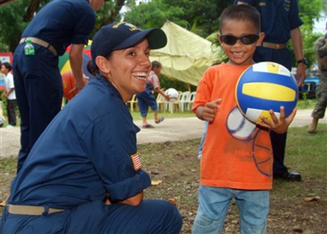 U.S. Navy Ensign Jennifer A. Sanders plays with a Filipino child during a friendship-building project between sailors from the USS Harpers Ferry (LSD 49) and a children's home in Zamboanga, Philippines, on May 31, 2007.   Harpers Ferry is participating in Cooperation Afloat Readiness and Training 2007, an annual series of bilateral maritime training exercises between the United States and six Southeast Asian nations designed to build relationships and enhance the operational readiness of the participating forces.  
