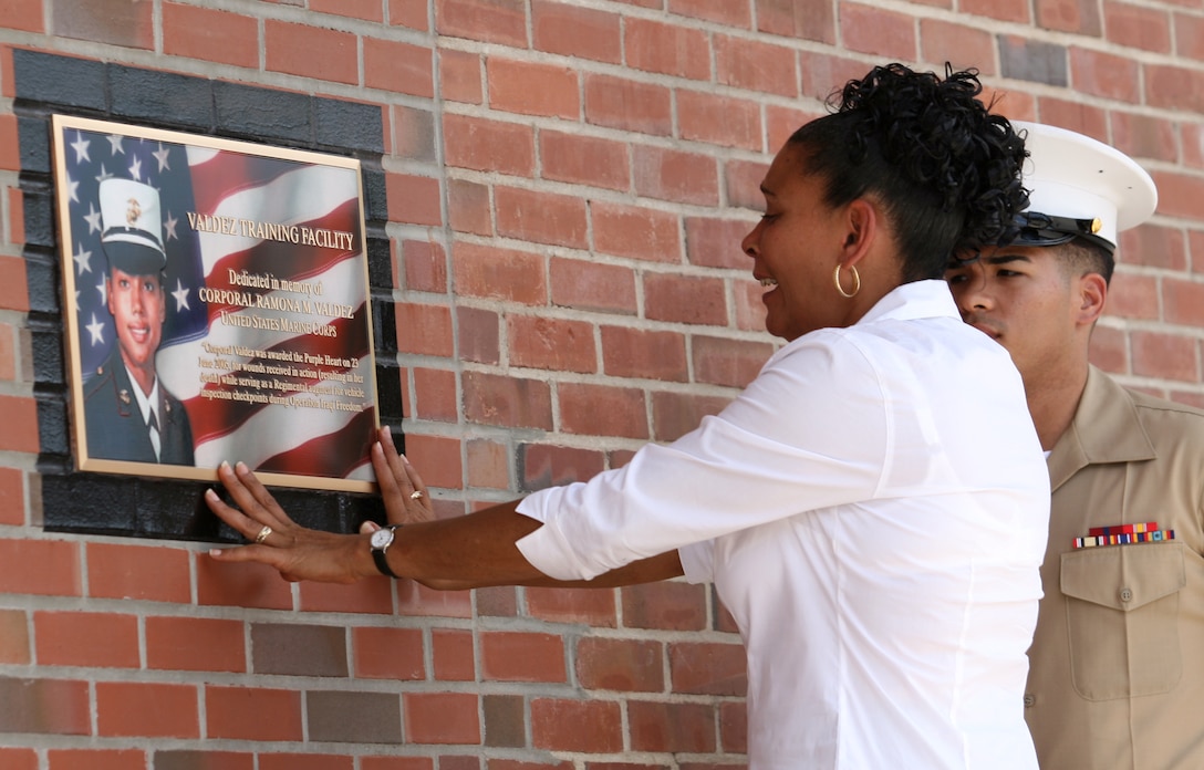 Elida Valdez, mother of Cpl. Ramona M. Valdez, touches a newly-revealed plaque outside the Valdez Training Facility during a building dedication ceremony here, June 1. Cpl. Valdez, a communication specialist with Headquarters Battalion, 2nd Marine Division, II Marine Expeditionary Force (Forward), was serving with the Female Search Force when she was killed after a suicide bomber attacked her convoy on its way back to Camp Fallujah, Iraq, June 23, 2005.